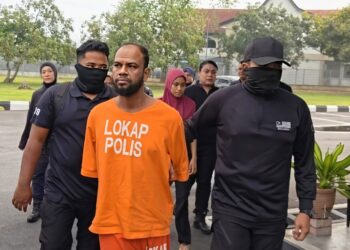OSMAN Bawdi Alom (tengah) diiringi oleh anggota polis ketika dibawa ke Mahkamah Majistret Jawi di Nibong Tebal, Pulau Pinang hari ini atas pertuduhan membunuh serta mencederakan pasangan suami isteri yang senegara dengannya, bulan lepas.-UTUSAN/ISWAN SHAFIQ ISA