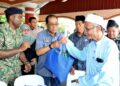 MOHAMED Khaled Nordin (tengah) menyampaikan bantuan kepada penduduk pada Majlis Perasmian Program Jiwa Murni Madani Kementerian Pertahanan di Sekolah Kebangsaan Johor Kampong, Kota Tinggi. UTUSAN/RAJA JAAFAR ALI