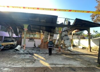 NUR Iliatie Asmira Alemee menunjukkan keadaan rumahnya yang terbakar di Kampung Lubok Stol, Rantau Panjang, Kelantan malam tadi.