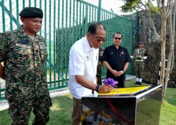 MENTERI Pertahanan, Datuk Seri Mohamed Khaled Nordin menandatangani plak ketika merasmikan Kem Segamat Fasa II sambil diperhatikan Panglima Tentera Darat, Jeneral Tan Sri Azhan Md Othman (kiri) sempena Lawatan Kerja ke Rejimen ke-4 Artileri Diraja Kem Segamat disini. UTUSAN/RAJA JAAFAR ALI