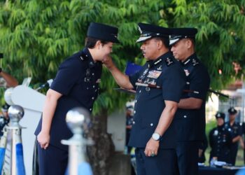 MOHD. Yusoff Mamat (kanan) memakaikan pangkat kepada pegawainya semasa perhimpunan bulanan di Ibu Pejabat Polis Kontinjen (IPK) Kelantan di Kota Bharu, Kelantan hari ini-UTUSAN/KAMARUL BISMI KAMARUZAMAN.
