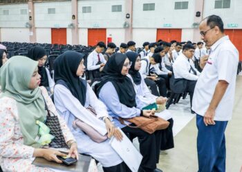 MOHD. Ruzi Hamzah (kanan) menyantuni beberapa pelajar baharu pada majlis perasmian MTS di PSP, Bukit Mertajam, Pulau Pinang baru-baru ini.