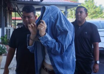 TANG Wee Tat (tengah) diiringi oleh anggota polis ketika dihadapkan ke Mahkamah Majistret Jawi di Nibong Tebal, Pulau Pinang atas 207 pertuduhan berkaitan memasuki kontrak serta menggunakan jawatan pengarah syarikat bagi urusan perniagaan.-UTUSAN/DANIAL SAAD