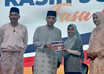 MENTERI Besar Johor, Datuk Onn Hafiz Ghazi bergambar salah seorang penerima sempena Majlis Penyerahan Inisiatif Perumahan Kasih Johor Fasa 4 di Austin International Convention Centre (AICC), Johor Bahru disini. UTUSAN/RAJA JAAFAR ALI