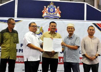 MOHD. Hairi Mad Shah (tengah) menyaksikan Pentadbir Tanah Johor Bahru Syed Norul Shahril Syed Nasir (dua dari kiri) menyerahkan Notis 5A kepada salah seorang penduduk pada Majlis Penyerahan Notis 5A Permohonan Perbaharui Tempoh Pajakan kepada penduduk Kampung Melayu Majidi di Medan Niaga Kampung Melayu Majidi, Johor Bahru disini. UTUSAN/RAJA JAAFAR ALI