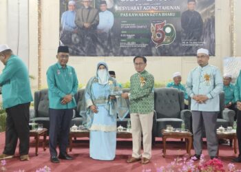 TAKIYUDDIN Hassan (kiri) semasa mengiringi menyampaikan penghargaan kepada bekas penghulu lantikan Pas di Parlimen Kota Bharu selepas Mesyuarat Agung Pas Kawasan Kota Bharu, Kelantan malam tadi-UTUSAN/YATIMIN ABDULLAH.