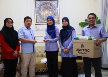NOR Aziemah Ismail (tiga kanan) menyerahkan sumbangan faedah kepada  Faedah Pengurusan Mayat dan Faedah Orang Tanggungan kepada Sharulanuar Baharom di lorong kubur Taman Mekasar, Kampung Kasar, Pasir Mas, Kelantan hari ini-UTUSAN/KAMARUL BISMI KAMARUZAMAN.