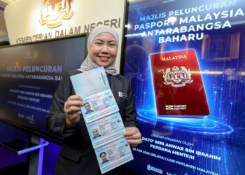 KAKITANGAN Bahagian Keselamatan Dan Pasport Ibu Pejabat Imigresen Putrajaya, Norshahida Zolkifly menunjukkan spesimen Pasport Malaysia Antarabangsa Baharu pada Majlis Pelancaran di Lobi Parlimen, Kuala Lumpur hari ini. - UTUSAN/FARIZ RUSADIO