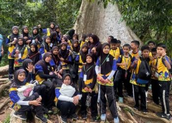 PESERTA  Kem Pintar 2.0 Sekolah Kebangsaan Kuala Tahan berehat di bawah pokok Tualang yang tertua di hutan tropika semasa bereksplorasi di Taman Negara Kuala Tahan, Jerantut, Pahang baru-baru ini. – utusan/HARIS FADILAH AHMAD