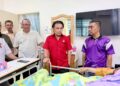 MOHD. Asna Amin (tengah) menyantuni seorang pesakit di Dewan Undangan Negeri Lenggeng.