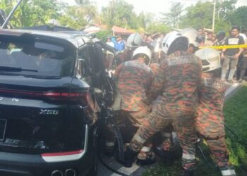 ANGGOTA bomba dan penyelamat berusaha mengeluarkan mangsa yang tersepit dalam kemalangan membabitkan Proton X50 dengan lori tanah.