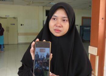 NUR Shafiqa Hani Mohd. Zuki menunjukkan gambar arwah suaminya yang lemas semasa mendulang emas di Sungai Ulu Galas, Pulai, Gua Musang, Kelantan.