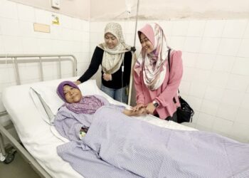 DR .Wan Immi Salim (kanan) menyantuni Jaslinda Saludin yang dirawat di Hospital Tapah. - GAMBAR IHSAN HOSPITAL TAPAH