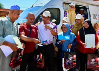 BADRUL Hisham Alias (tiga dari kiri) menyerahkan dokumen sijil kelahiran dan kad pengenalan baru kepada penerima pada Program Santuni Madani di Kampung Padang Tanjung, Bukit Payung, Kuala Terengganu, Terengganu. - UTUSAN/PUQTRA HAIRRY
