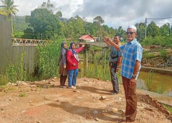 PENDUDUK menunjukkan projek pembinaan jambatan terbengkalai yang menjejaskan kehidupan harian mereka di Sik Dalam, Sik, Kedah, semalam.