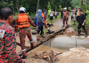 ANGGOTA bomba membantu menyelamatkan mangsa yang terperangkap akibat kepala air di Kampung Permatang Keramat, Jalan Batu Hampar di Yan.