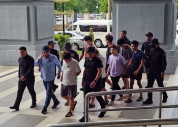SEBAHAGIAN daripada 13 lelaki yang didakwa terlibat dalam satu rusuhan di Jinjang Utara ketika tiba di Kompleks Mahkamah Kuala Lumpur, di sini hari ini.