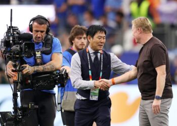 PENGENDALI Belanda, Ronald Koeman (kanan) bersalaman dengan rakan sejawatannya dari Jepun, Hajime Moriyasu sejurus tamat perlawanan yang menyaksikan kedua-dua pasukan seri 2-2 di Stadium Dallas, semalam. - AFP