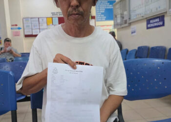HASZMAN Othman menunjukkan laporan polis yang dibuat di IPD Tapah hari ini terhadap  akaun TikTok yang didakwa mengaib dan memfitnah isterinya, Jaslinda Saludin. - UTUSAN/AIN SAFRE BIDIN