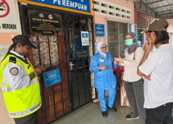 HASZMAN Othman (kanan) berbual dengan doktor semasa melawat isterinya, Jaslinda Saludin di Hospital Tapah hari ini. - UTUSAN/AIN SAFRE BIDIN