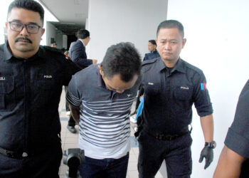 HARRIS Mohd Abd Nasir didakwa atas tuduhan membunuh rakannya, dibawa keluar dari Mahkamah Majistret Ayer Keroh, hari ini. - UTUSAN/AMRAN MULUP