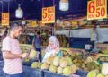 PEKERJA kedai durian menunjukkan isi durian kepada pelanggan ketika tinjauan Utusan Malaysia di sebuah gerai durian di sekitar Sentul, semalam. – UTUSAN/ISKANDAR ISHAK