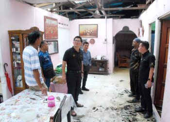 LIM Ban Hong melihat salah sebuah rumah yang rosak bahagian bumbung dalam kejadian ribut di Pulau Gadong, Klebang, Melaka. - UTUSAN/AMRAN MULUP