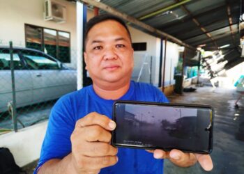 LIEW Kim Seng menunjukkan rakaman video kejadian ribut pada Jumaat lalu di Bercham, Ipoh, Perak. - UTUSAN/FADZIL ZAINOL