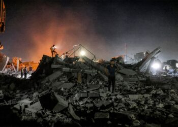 BEBERAPA orang memeriksa lokasi pengeboman Israel di Khan Yunis, Gaza semalam. - AFP