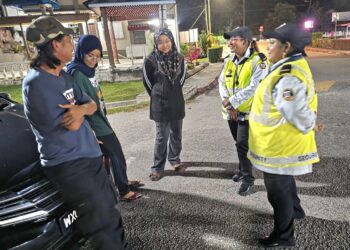 HASZMAN Othman (kiri) dan dua anak Jaslinda Saludin bersama anggota polis menunggu wanita tersebut untuk dibawa mendapatkan rawatan di Hospital Tapah hari ini. - UTUSAN/AIN SAFRE BIDIN