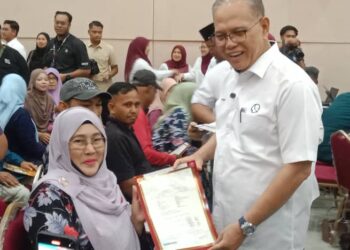 WAN Rosdy Wan Ismail (kanan) menyampaikan suratan hak milik kepada seorang penerima daripada generasi baharu Felda Kota Gelanggi Dua di Jerantut, Pahang.