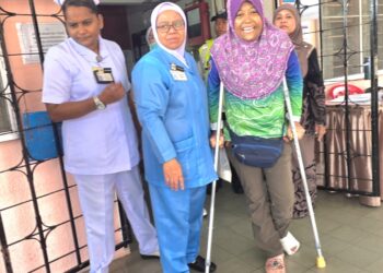 JASLINDA Saludin berjalan menggunakan topang ketika keluar dari Hospital Tapah hari ini.  - UTUSAN/AIN SAFRE BIDIN