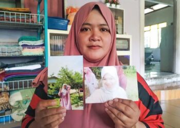 NURHASLIZA Yusof menunjukkan gambar kenangan Fatien Nasrien Fadli ketika ditemui di Kampung Kerandang, Besut, Terengganu. - UTUSAN/WAN ZURATIKAH IFFAH WAN ZULKIFLI