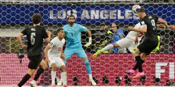 Penyerang New Zealand, Chris Wood (kiri) menanduk bola melepasi penjaga gol Iran, Alireza Beiranvand ketika aksi Kumpulan G Piala Dunia 2026 di Stadium Los Angeles, Inglewood, hari ini, yang berakhir dengan keputusan seri 2-2. – AFP