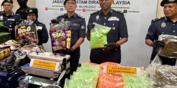 AMRAN Ahmad (tengah) menunjukkan bungkusan dadah yang dibungkus dalam plastik makanan untuk diseludup ke pasaran antarabangsa dalam sidang akhbar Kejayaan JKDM Menumpaskan sindiket pengedaran dadah antarabangsa di Ibu Pejabat Cawangan Narkotik JKDM, Nilai, Seremban semalam.- UTUSAN / NOR SHAFIQAH MOHD GHAZALI