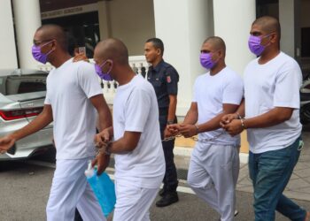 EMPAT lelaki diiringi anggota polis ketika dibawa ke Mahkamah Tinggi Pulau Pinang hari ini atas pertuduhan membunuh seorang mangsa buli, T. Nhaveen pada 2017.-UTUSAN/DANIAL SAAD