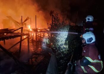 ANGGOTA bomba memadam kebakaran membabitkan 12 buah rumah di Kampung Kalansanan, Inanam, Kota Kinabalu, Sabah.-UTUSAN/HARDY JOE