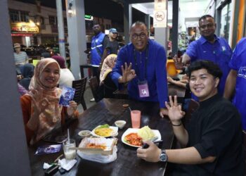 PANDAK Ahmad menyantuni penduduk setempat ketika membuat walkabout di Taman Nusantara, Iskandar Puteri, malam tadi.