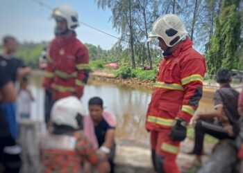 ANGGOTA bomba menenangkan mangsa selepas kereta dinaiki terjunam ke dalam kawasan pintu air Sungai Pengkalan Petah, Tawang, Bachok, Kelantan hari ini.