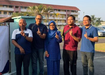 ALWIYAH (tengah) ditemani keluarga ketika mengundi di Sekolah Kebangsaan Sawah Dato' pagi ini.