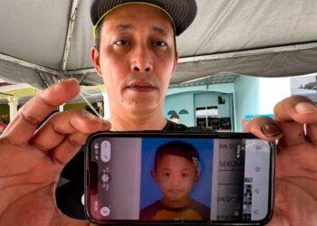 KHAIRUL ANNUAR Salim menunjukkan gambar anak saudaranya, Muhammad Umar Mohd . Faaiz yang meninggal dunia akibat dilanggar bas sekolah di Taman Sri Lalang, Kluang petang semalam.