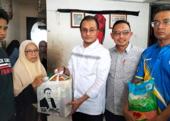 MOHAMAD Abdul Hamid (tengah) menyerahkan bantuan kepada Salmah Samsudin di kediaman mereka di Bukit Gedung, Pulau Pinang, petang semalam.