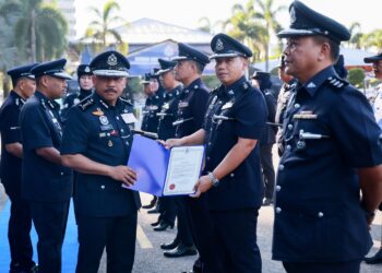 MOHD. Yusoff Mamat menyampaikan anugerah kepada pegawai polis pada majlis perhimpunan bulan polis di Ibu Pejabat Polis Kontinjen (IPK) Kelantan, Kota Bharu, Kelantan semalam. - UTUSAN/KAMARUL BISMI KAMARUZAMAN.