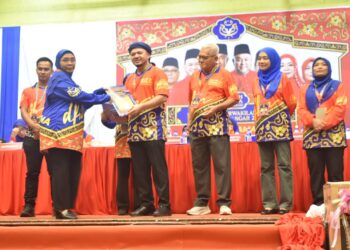 FATHUL Bari Mat Jahya (empat dari kanan) menyampaikan watikah Pengerusi Pusat Daerah Mengundi (PDM) pada perasmian Mesyuarat Perwakilan UMNO Bahagian Kangar di Dewan Warisan, Kangar, Perlis, hari ini.-UTUSAN/ASYRAF MUHAMMAD