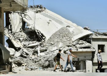 PENDUDUK berjalan di sekitar runtuhan rumah dan premis perniagaan yang musnah dalam serangan Israel di kampung Srifa di selatan Lubnan.- AFP