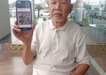 MOHAMAD Rozi Yusof menunjukkan keratan Utusan Malaysia tentang laporan tragedi platform runtuh di Pangkalan Sultan Abdul Halim di Pulau Pinang.