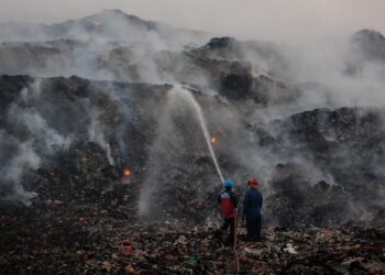 ANGGOTA bomba dan petugas BNPB memadam sisa kebakaran di kawasan pelupusan sampah Jatiwaringin di Tangerang di Banten, Indonesia.-AFP