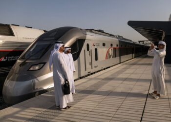 BEBERAPA lelaki bergambar di hadapan kereta api penumpang pertama UAE dikendalikan Etihad Rail sempena perjalanan sulungnya di Stesen Mohamed bin Zayed di Abu Dhabi.-AFP