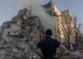 SEORANG lelaki melihat sebuah bangunan kediaman yang rosak akibat serangan udara Russia ke atas Kyiv kelmarin. - AFP