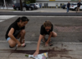 DUA wanita meletakkan lilin dan bunga berhampiran lokasi Lorenzo Salgado Araujo ditembak pegawai ICE ketika pemeriksaan kenderaan di Houston, Texas.-AGENSI